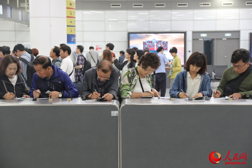 旅客在填寫入境信息。人民網 霍亞平攝