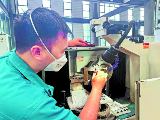 富耐克生產(chǎn)車間工人正在調(diào)試設(shè)備。王佳寧 攝